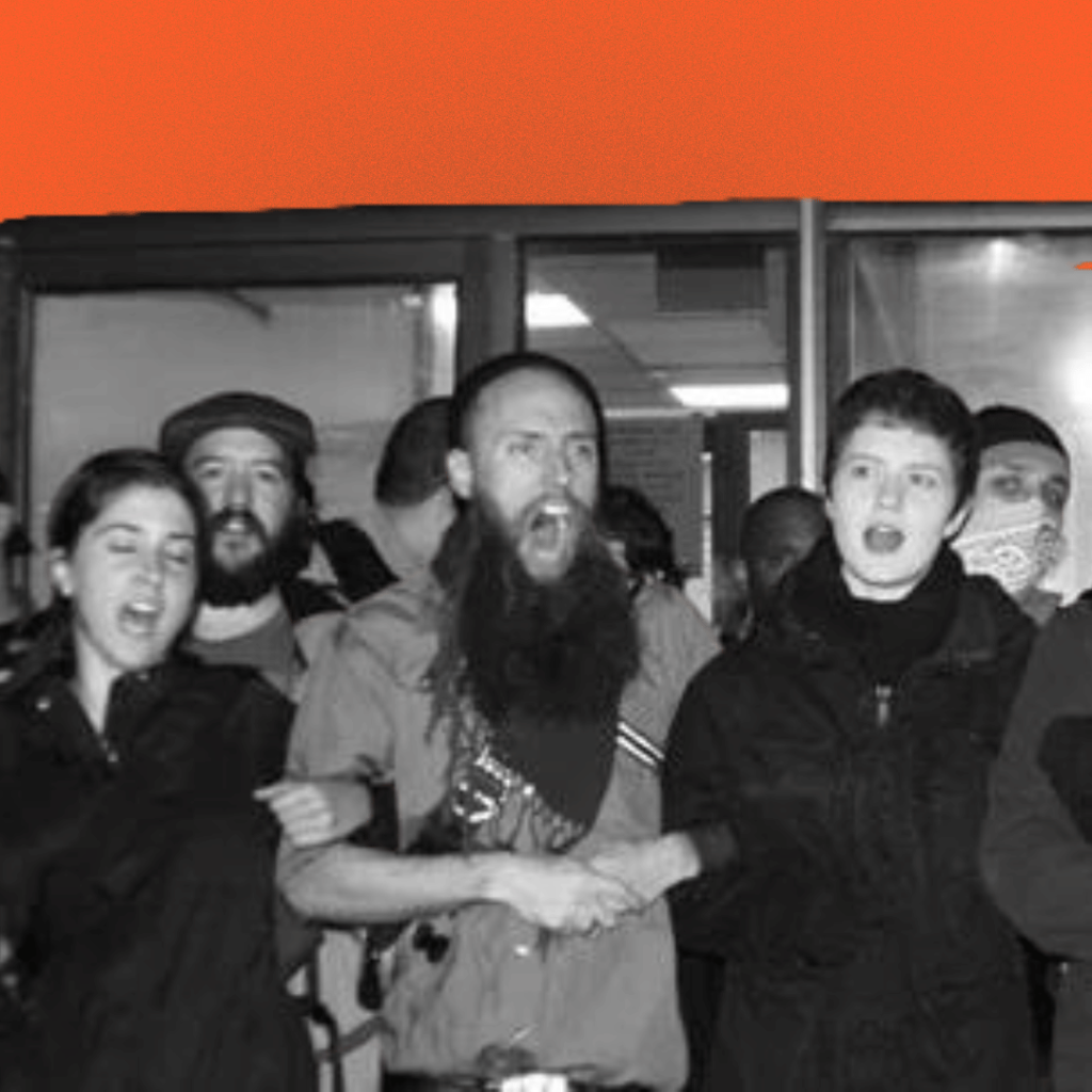 A black-and-white image of people at a protest linking arms.